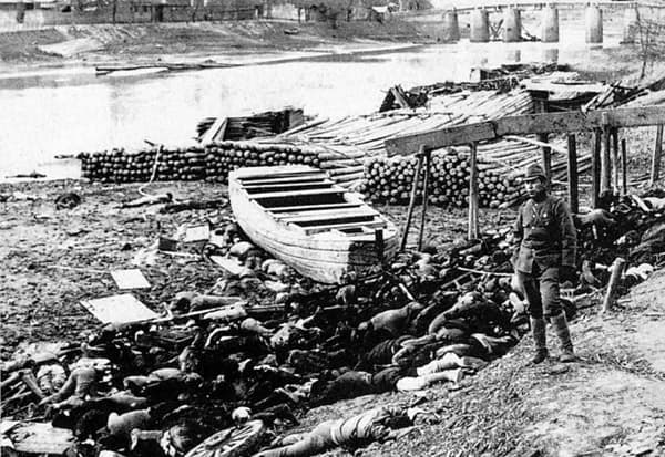 A Japanese soldier stands next to Chinese victims of the Nanking Massacre.