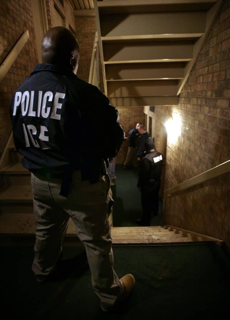 U.S. Immigration and Custom Enforcement Supervisory deportation officer Raymond Smith stands watch as a fugitive operation team works during an early morning operation. (Yuri Gripas/KRT) (Credit Image: © Yuri Gripas/TNS/ZUMAPRESS.com)