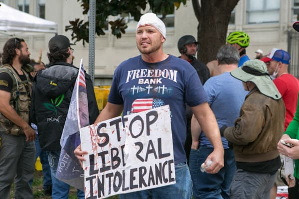 An injured Trump supporter holds a sign during a free speech rally in Berkeley, California. (Credit Image: © Emily Molli/NurPhoto via ZUMA Press)