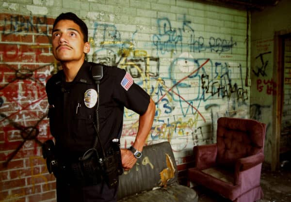 Atlanta, GA, — A police officer walks through a Hispanic gang hangout in an abandoned carpet dye plant. The gangs use the building as a drug marketplace. (Credit Image: Robin Rayne / ZUMAPRESS.com)