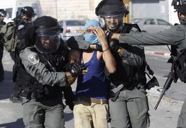 Israeli border policemen arrest a Palestinian youth