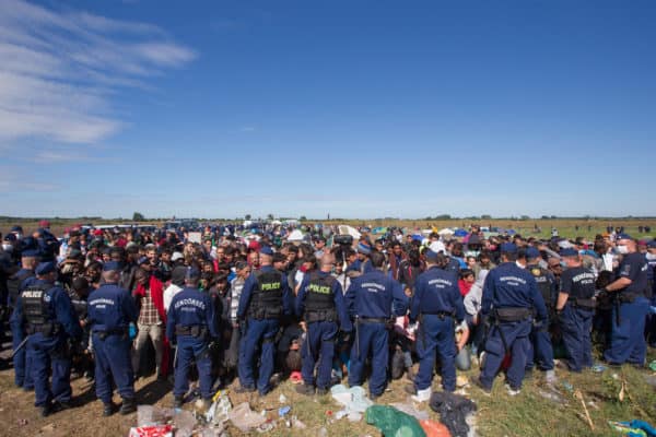 Hungarian police officers stand guard at a gathering point of illegal migrants