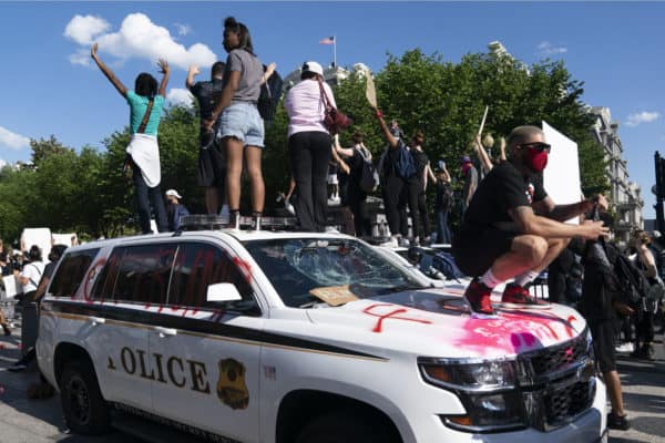 Protestors atop police vehicle