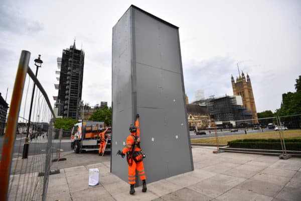 Workers begin the deconstruction of the boarding around the Winston Churchill statue