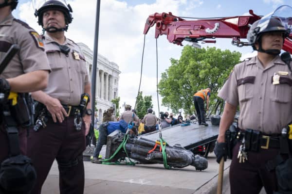 Minnesota State Troopers surround the statue of Christopher Columbus after it was toppled in front of the Minnesota State Capitol in St. Paul, Minn., on Wednesday, June 10, 2020. (Credit Image: © TNS via ZUMA Wire)