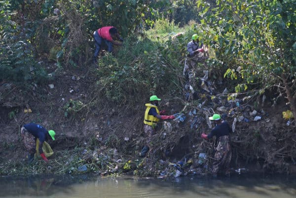 Volunteers collect rubbish near a river in Pretoria
