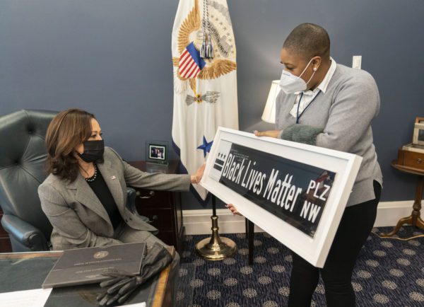 16 年 2021 月 XNUMX 日——华盛顿特区——副总统西蒙·桑德斯的首席发言人在她的白宫西翼办公室向副总统卡马拉哈里斯展示了一个“黑人的命也是命”的路牌。 该标志是 DC 市长穆里尔·鲍泽 (Muriel Bowser) 赠送的礼物。 （图片来源：© Lawrence Jackson / White House / ZUMA Wire / ZUMAPRESS.com）