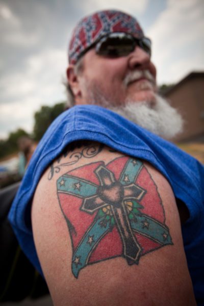 26 年 2012 月 XNUMX 日，在佐治亚州东都柏林举行的夏季乡下人运动会上，一名男子炫耀他的邦联旗帜纹身。 （图片来源：© Richard Ellis / ZUMAPRESS.com）
