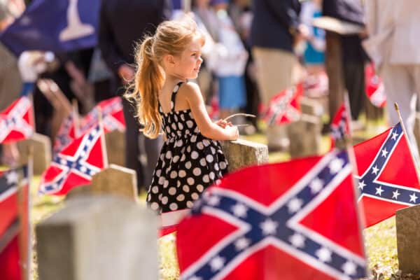 May 10, 2014 – Charleston, South Carolina – A young girl stands among Confederate flags decorating tombs of soldiers killed in the American Civil War during Confederate Memorial Day events at Magnolia Cemetery. (Credit Image: © Richard Ellis / ZUMAPRESS.com)