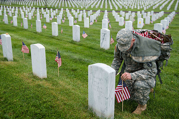 一名来自老卫队的美国陆军士兵在阿灵顿国家公墓的墓地前放置旗帜。 自 1948 年以来，老卫队一直在举行插旗仪式，每块墓碑上都插着一面美国国旗。（图片来源：© Rachel Larue/Planet Pix via ZUMA Wire）