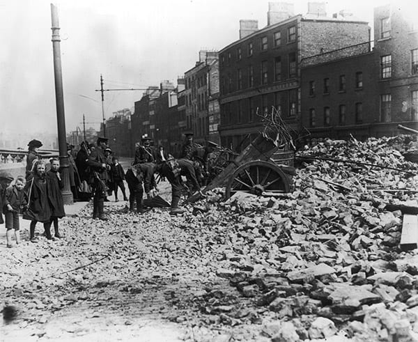 Civilian children watch soldiers amid the rubble and ruins of a Dublin street during the Easter uprising of 1916. (Credit Image: © Mary Evans via ZUMA Press)